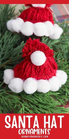 two knitted santa hats sitting on top of a christmas tree