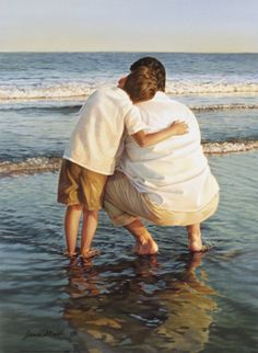 two people hugging each other on the beach