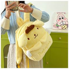 a woman holding a yellow stuffed animal backpack