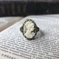 18x13mm green and white acrylic cameo of a lady.Available on an antiqued brass or silver adjustable victorian cigar band ring. Easy to adjust to most sizes. White Woman, Cameo Ring, White Acrylic, White Acrylics, A Lady, Antique Rings, Green And White, Band Ring, Antique Brass