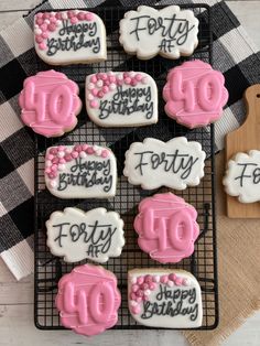 decorated cookies on a cooling rack with happy birthday written on the icing and pink frosting