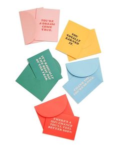 four different colored envelopes with words on them