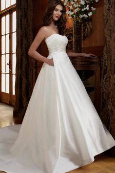 a woman in a white wedding dress posing for the camera