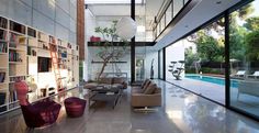 a living room filled with furniture next to a swimming pool