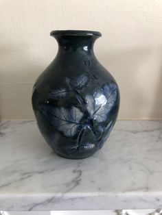 a blue vase sitting on top of a marble counter