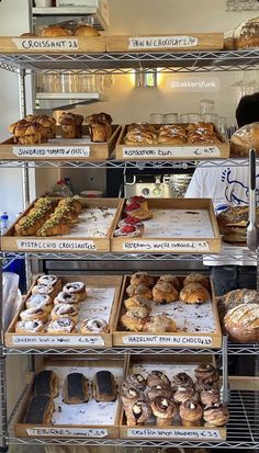 an assortment of baked goods displayed on shelves in a bakery display case, with labels describing the different types of baked goods