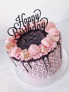 a birthday cake decorated with pink and black frosting