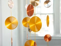 a wind chime hanging from the ceiling in a room with white walls and windows