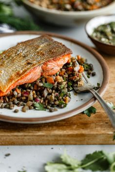 a white plate topped with salmon and lentils