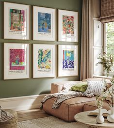 a living room with green walls and pictures on the wall above the couch, along with a coffee table