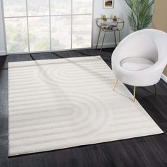 a white rug in a living room with a chair and potted plant on the floor