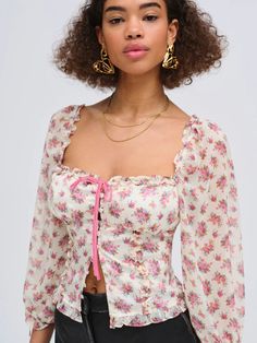 Explore a world of delicate hues and charming flower patterns with the Etienne pink top—a dainty floral blouse with three-quarter chiffon sleeves and ruffle accents made of satin. This vintage-inspired design also boasts a shirred bodice and a whimsical decorative bow at the center. The Etienne Top is designed to be fitted and fits true to size. Style Notes Lined bust panel Elasticized puff sleeves Functional button placket and tie at the center-front Non-functional ties at the elasticated sleev Romantic Tops, Chiffon Sleeves, Three Quarter Sleeve Tops, Sweater Crop, Floral Outfit, For Love & Lemons, Crop Top Sweater, Tops Online, Little White Dresses