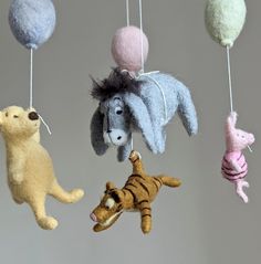 several stuffed animals hanging from strings in the shape of balls with tails and tailes