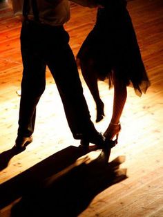 two people dancing on a wooden floor with their feet in the dancefloors