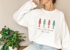 This Christmas Crew Nutcracker Sweatshirt is perfect for Nutcracker fans and Christmas lovers. This shirt features a retro style Christmas design and pastel color scheme. It's perfect for your next holiday party! Ideal for any situation, a unisex heavy blend crewneck sweatshirt is pure comfort. These garments are made from polyester and cotton. This combination helps designs come out looking fresh and beautiful. The collar is ribbed knit, so it retains its shape even after washing. There are no itchy side seams on these sweaters.  *50% cotton, 50% polyester *Medium-heavy fabric (8.0 oz/yd² (271.25 g/m *Loose fit *Sewn-in label *Runs true to size Washing Instructions: Machine wash: warm (max 40C or 105F); Non-chlorine: bleach as needed; Tumble dry: medium heat; Do not iron; Do not dryclean. Nutcracker Gifts Ballet, Nutcracker Shirt, Ballet Gift, Italy Gift, Pastel Color Schemes, Christmas Lovers, Aperol Spritz, Travel Shirts, Christmas Design