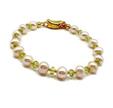 Peridot and Pearl bracelet, August birthstone. June birthstone, Gold vermeil, birthday gift, Mother's Day gift, Pearl jewellery  A stunning bracelet featuring sparkly faceted Peridot and beautiful freshwater cultured Pearls. This gorgeous bracelet is finished with sterling silver which is plated with 18kt Gold bean shaped buckle clasp. Length of bracelet:  7.5 inches Pearl size: 6-5.5mm approximately  Peridot size:  4x2mm approximately  Bean buckle size:  22mm x 7mm Beautifully presented in a gift box wrapped with ribbon.   Peridot is August birthstone and 16th wedding anniversary gemstone. Pearl is June birthstone and 3rd and 30th Wedding Anniversary. Yellow Gold May Birthstone Bracelets For Anniversary, Yellow Gold Bracelets For Anniversary, May Birthstone, Classic Birthstone Bracelets For Anniversary, Yellow Gold Jewelry For May Birthstone Birthday, Yellow Gold Jewelry For Birthday With May Birthstone, Elegant Pearl Bracelet For Birthday, Elegant Round Pearl Bracelet For Birthday, Birthstone Round Beads Jewelry For Birthday, Round Beads Birthstone Jewelry For Birthday