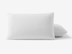 two pillows sitting next to each other on a white surface