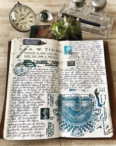 an open book with writing on it next to a clock and other items sitting on a table