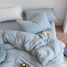 a blue and white checkered comforter on top of a bed next to pillows