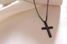 Introducing our Black Cross Pendant Necklace, a stylish and versatile accessory designed for both children and adults. This necklace features a sleek black cross pendant suspended from a black hip-hop long chain, creating a trendy and unisex piece suitable for various styles. Key Features: 1. Black Cross Pendant: The focal point of this necklace is the sleek black cross pendant, offering a modern and fashionable twist to the classic cross design. The pendant is crafted with attention to detail, showcasing a contemporary and elegant aesthetic. 2. Black Hip Hop Long Chain: The necklace features a black hip-hop long chain, adding a trendy and edgy element to the overall design. The chain's length and style make it a versatile accessory suitable for various outfits and occasions. 3. Unisex Des Black Cross Necklace As Gift, Black Cross Pendant Necklace Gift, Black Cross Pendant Chain Necklace, Minimalist Black Cross Pendant Necklace, Black Symbolic Cross Pendant Necklace, Elegant Black Cross Pendant Necklace, Black Metal Cross Necklace, Black Stainless Steel Cross Pendant Necklace, Necklace Chain Types