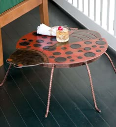 a coffee table made out of metal and wood with polka dot design on the top