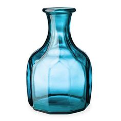 a blue glass vase sitting on top of a white table