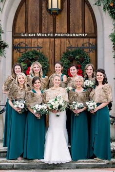 a group of women standing next to each other in front of a door with wreaths