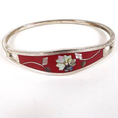 "Nice floral design with inlaid abalone shell and red enamel.  Size: Bracelet is 5/8\" wide at its widest point and has an opening of 2 3/8\". Type: Pre Owned Retro Vintage from the 1980's.  Condition: Metal has darkened patina. Hinge in good working condition and locks shut as it should. There was a sticker on the back from previous owner, but it has been removed. Materials: Silver tone metal, enamel, inlaid abalone shell. Markings: Marked Taxco Mexico on the back." Red Enamel Bangle Bracelet, Red Enamel Bangle Bracelets, Handmade Red Enamel Bracelets, Red Enamel Bangle Jewelry, Red Enamel Bangle, Red Enamel Bracelet Jewelry, Distinctive Bangle With Inlay For Gifts, Unique Bangle With Inlay As Gift, Unique Inlay Bangle Gift