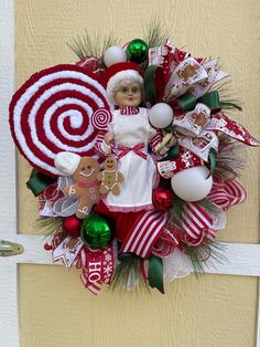 a christmas wreath on the front door with candy canes, ornaments and a gingerbread man