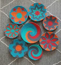 six colorful bowls sitting on top of a gray carpet next to each other and one has an orange, red, blue, and green flower design in the middle