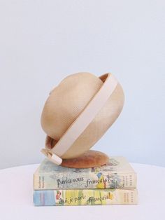 Beautiful 60’s fine weave beige dome style hat.Wide upturned brim with cream grosgrain ribbon trim.Made in England for “Alexander’s”.Measurements: 21” Circumference inside6” height to top of button29” circumference outside brimBrand/Maker: Made in England for Alexander'sCondition: Excellent!•Please feel free to message me with any additional questions *{ Instagram. Hamptonsvintagemarket }{ Facebook. @HamptonsVintageMarket } Beige Cloche Hat With Short Brim For Kentucky Derby, Beige Short Brim Cloche Hat For Kentucky Derby, Beige Cloche Straw Hat For Kentucky Derby, Retro Beige Short Brim Hat, Vintage Beige Hat Band For Summer, Cream Mini Hat With Short Brim, Retro Beige Hat With Curved Brim, Retro Adjustable Cloche Hat With Curved Brim, Classic Cream Cloche Hat With Curved Brim