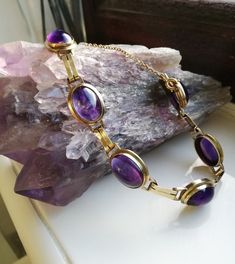 "A sumptuous antique Art Deco bracelet, housing the most beautifully intense cabochons of amethyst. Most probably created in the 1920s era in Germany, as 8ct gold (often stamped \"333\" as in this case) was used there quite a lot in the first decades of the twentieth century. It screams the Art Deco designs of the era, both in its use of those parallel strips of gold as connectors between each large cabochon and also its use of purple in these wonderful stones. I love this bracelet- it wears so Antique Purple Bracelets For Formal Occasions, Formal Round Amethyst Bracelets, Formal Amethyst Round Bracelets, Formal Amethyst Bracelets, Antique Round Gemstone Bracelets, Antique Gemstone Bracelets, Formal Amethyst Oval Cabochon Jewelry, Formal Amethyst Jewelry, Oval Cabochon, Antique Oval Gemstone Bracelets