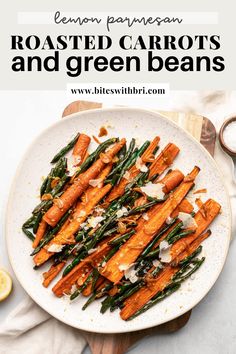 roasted carrots and green beans on a white plate with lemon wedges next to it