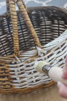 someone is painting the inside of a wicker basket