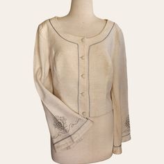 This stunning womens cropped jacket, crafted from a lined Linen blend by Brown Sugar, is a gem from the 1970s Hippie movement. It features bell-shaped long sleeves adorned with exquisite embroidery near sleeve ends. The embroidery is complemented by piping of the same color along the sleeve hem, front panels, and neckline. Covered buttons provide the perfect finishing touch to this elegant statement item for your retro vintage spring collection. Hand-laundered since acquired by HRV. -  Button Up Elegant Long Sleeve Cropped Jacket With Buttons, Elegant Beige Cropped Jacket With Long Sleeves, Elegant Beige Long Sleeve Cropped Jacket, Fitted Beige Cropped Jacket For Formal Occasions, Fitted Beige Cropped Jacket With Buttons, Beige Fitted Cropped Jacket With Buttons, Vintage Long Sleeve Cropped Jacket For Spring, Fitted Vintage Cropped Jacket, Fitted Vintage Cropped Jacket For Spring