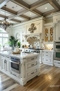 a large kitchen with white cabinets and wood flooring, along with an island in the middle