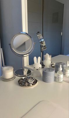 a bathroom counter with various items on it and a mirror in the corner behind it