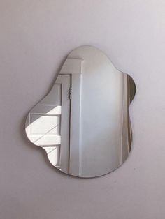 a mirror that is on the wall with a reflection of it's own door