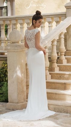 a woman in a wedding dress standing on stairs