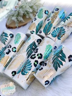 four wrapped gift boxes sitting on top of a white furnishing covered table next to a potted plant