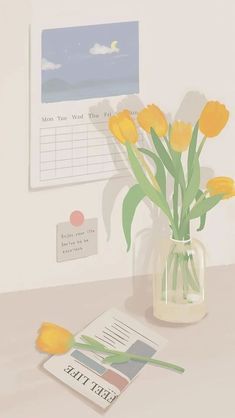 a vase filled with yellow flowers sitting on top of a table next to a calendar