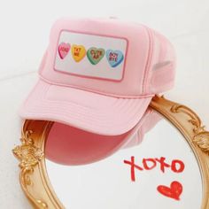 a pink hat sitting on top of a mirror next to a sign that says i love you