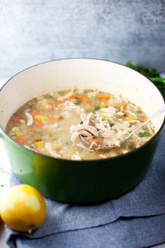 a green pot filled with soup next to a lemon