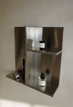 a shelf with some bottles and other items on it in the shape of a cube