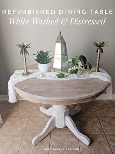 a dining table with white washed and distressed wood in the center, surrounded by potted plants