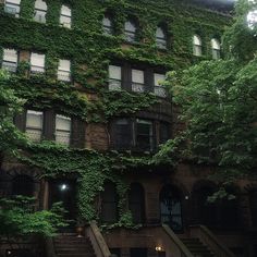 an old building with ivy growing on it's side and stairs leading up to the second floor