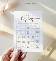 a hand holding up a baby shower game with the words find the guest on it