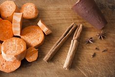 sliced carrots and cinnamon on a cutting board with an orange peel, cinnamon sticks, star anisette and spice