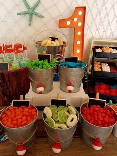 several buckets filled with different types of food on top of a wooden table in front of a starfish sign