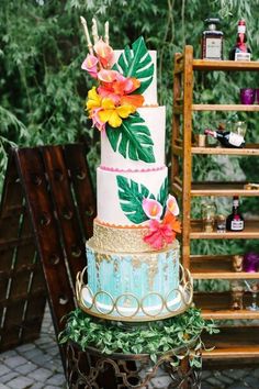 a multi layer cake decorated with flowers and leaves